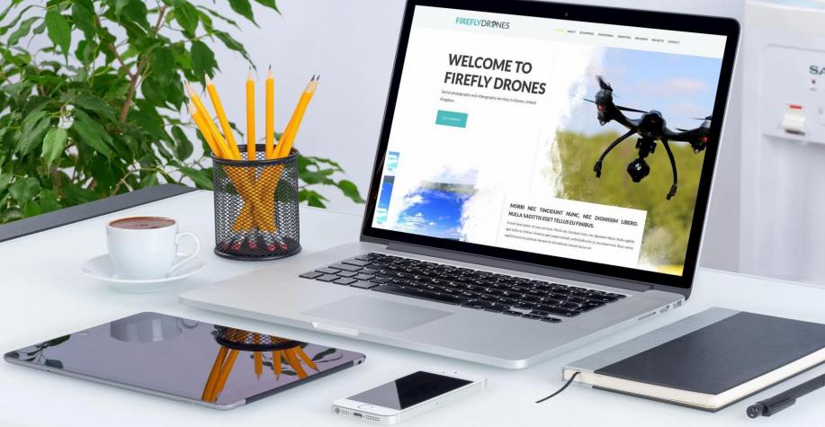 Firefly Drones website displayed on a Macbook on a white desk