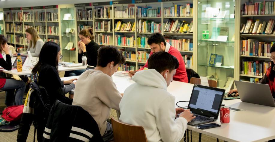 People studying at tables in a library
