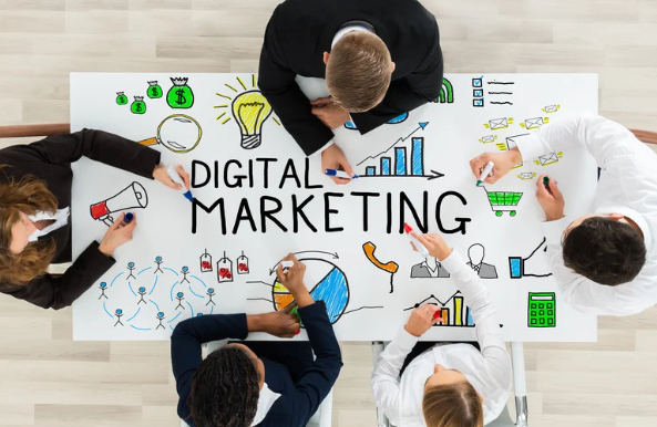People at a table covered in icons and writing saying Digital Marketing