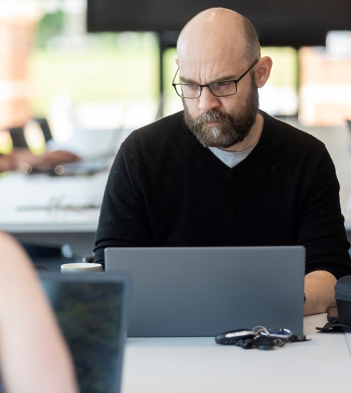 Devon web developers Man looks at a laptop with a concentrating look upon his face