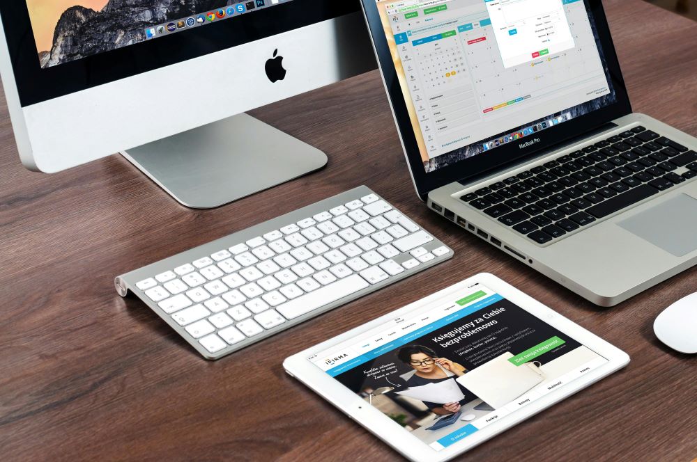 Website designers East Devon A laptop, tablet and PC on a desk displaying a website design
