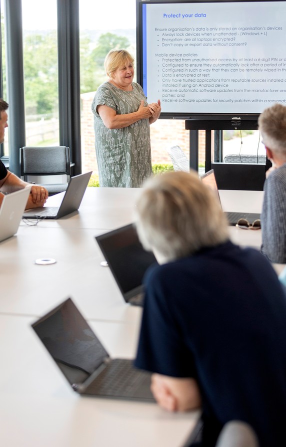 Senior Trainer standing at the front of a room delivering training