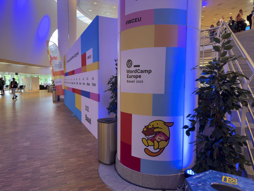WordCamp Europe branded pillar and billboard showing the previous locations of the annual conference