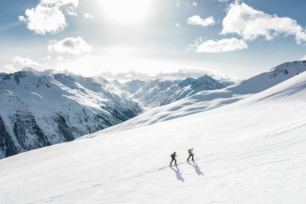 Two people hiking up a snowy mountain