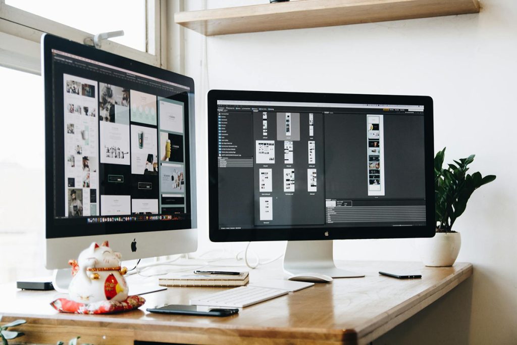 Two computer monitors showcasing design concepts
