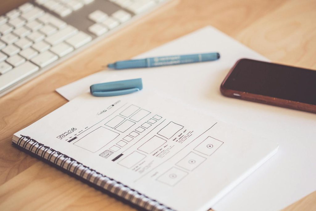 Wireframes for a new website drawn on a notepad