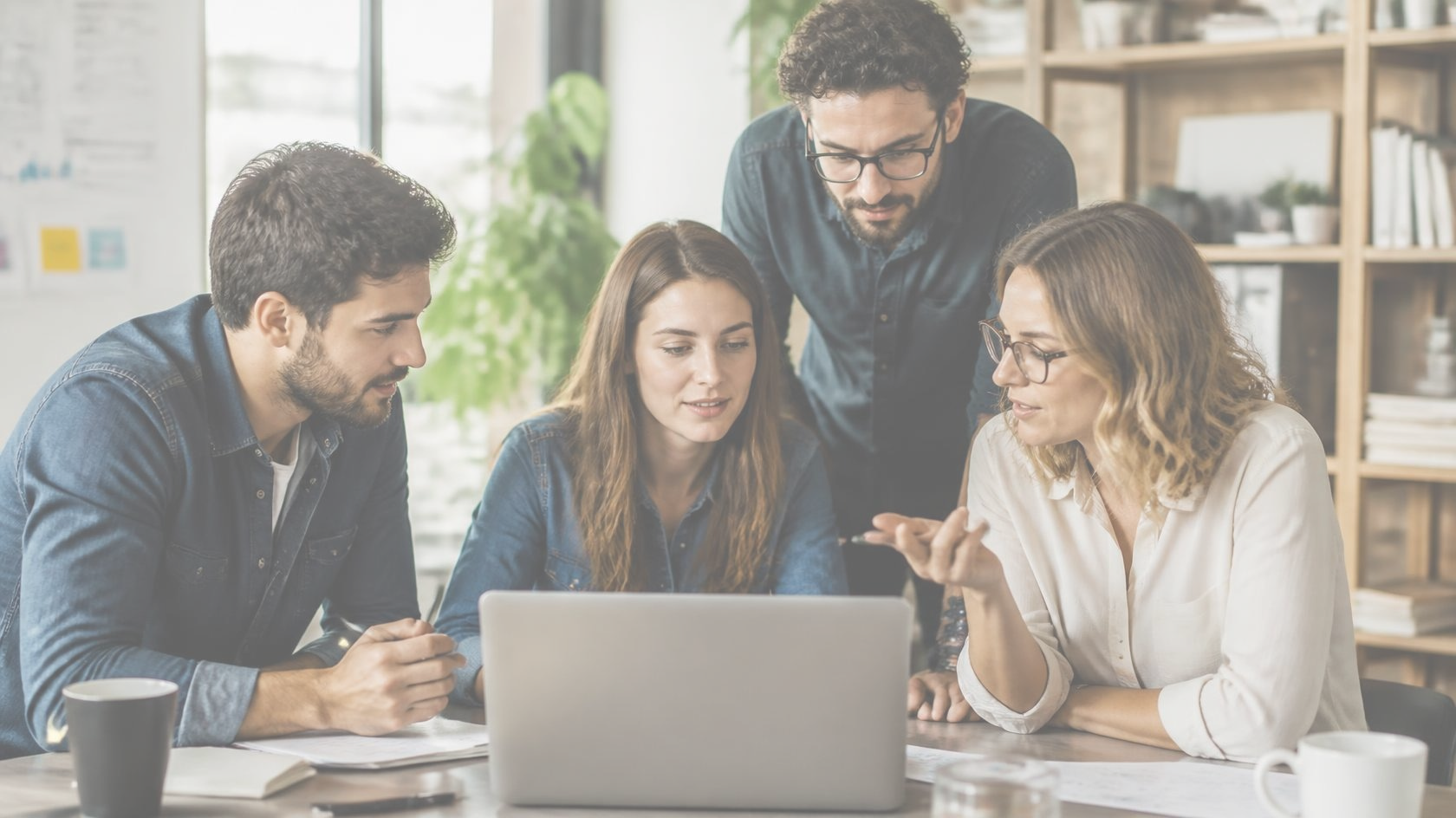 People looking at a laptop together while discussing a plan
